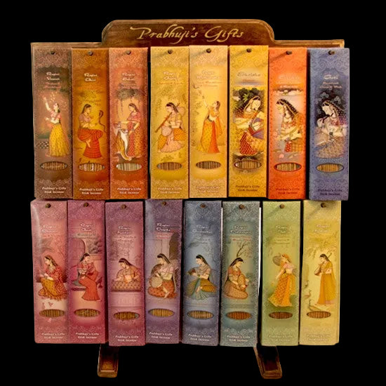 A display rack with multiple incense packs, each illustrated with traditional artwork depicting women in various poses and attire, in a variety of colors. Mystic Journey Path